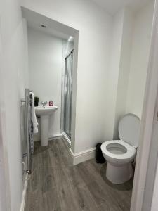 a white bathroom with a toilet and a sink at Charles Street House in Redcar