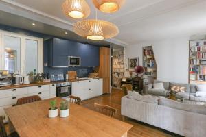a kitchen and living room with a table and a couch at Spacious apartment near the Villette in Paris