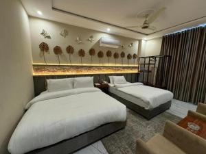 a hotel room with two beds and a couch at Doolv Guest House in Islamabad