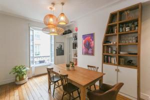 a dining room with a wooden table and chairs at Spacious apartment near the Villette in Paris