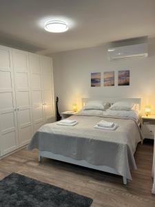 a bedroom with a large bed with two towels on it at Bodza Vendégház in Badacsonyörs