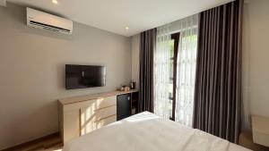 a bedroom with a bed and a tv and a window at Sunset Marina Hotel in Phu Quoc