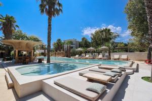a swimming pool with lounge chairs and a resort at NŪSA suites & villas in Pefkohori