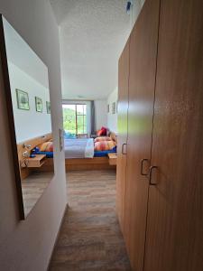 1 Schlafzimmer mit 2 Betten und einem Schrank mit einem Spiegel in der Unterkunft Ferienland Sonnenwald Ferienwohnung im Sonnenwald Apartment 5 in Langfurth 