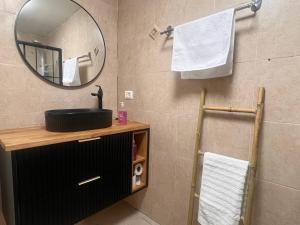 a bathroom with a sink and a mirror and towels at בית הקונגרס גבעת אולגה in H̱adera +12 photos