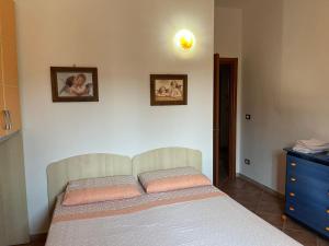 ein Schlafzimmer mit einem Bett mit zwei Bildern an der Wand in der Unterkunft Villa Pergola in San Michele Salentino