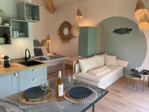 a living room with a couch and a table with wine glasses at Le lagon Bleu suite 5 étoiles in Les Issambres