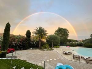 a rainbow in the sky over a swimming pool at Le lagon Bleu suite 5 étoiles villa Côté Cœur in Les Issambres +9 photos