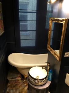 a bathroom with a tub and a toilet and a mirror at Room F - Louvre Museum - Shared bathroom with host in Paris