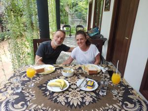 a man and a woman sitting at a table with food at Hotel Awaken in Dambulla