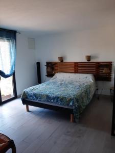 a bedroom with a bed with a wooden headboard at Chez Louise in Arboussols