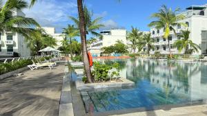 a pool at a resort with palm trees and buildings at Sunset Marina Hotel in Phu Quoc
