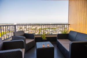 a balcony with chairs and tables and a view of a city at Love Horizons - Suite vue panoramique - Spa privatif - Rennes Centre in Rennes