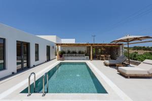 a swimming pool in the backyard of a house at Noble Pearl Villas Paros in Santa Maria