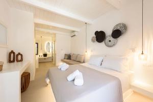 Un dormitorio blanco con una cama con toallas. en Noble Pearl Villas Paros, en Santa Maria 174 fotos más
