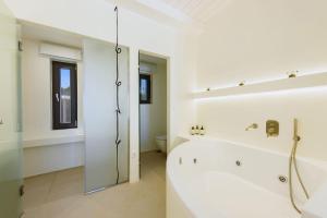 Un baño blanco con bañera y ducha. en Noble Pearl Villas Paros, en Santa Maria