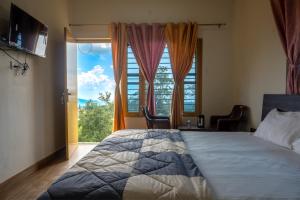 een slaapkamer met een groot bed en een groot raam bij Nature's View Kandwari in Pālampur