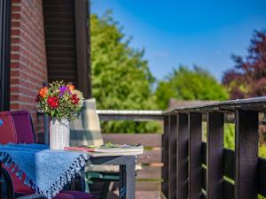 un tavolo con un vaso di fiori su un patio di La Casa Ferienwohnung Strandweg a Steinberg Altre 19 foto