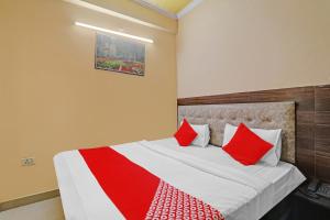 a bedroom with a large bed with red pillows at Hotel O Four Square in Lucknow