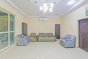 a living room with two chairs and a couch at Hotel O Four Square in Lucknow +16 photos