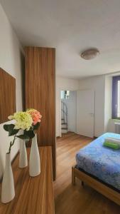 a bedroom with two white vases with flowers in it at La Torretta in Lanzo dʼIntelvi