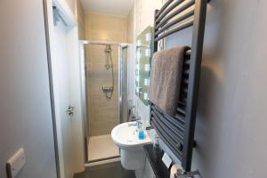 a bathroom with a toilet and a shower and a sink at The Horseshoe Bar Townhouse Accommodation in Listowel +23 photos