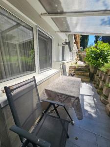 a porch with a bench and a table and a chair at Wohnung Hochbild in Überlingen +3 photos