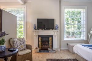 a living room with a fireplace with a flat screen tv at Sandown Lodge in Cape Town