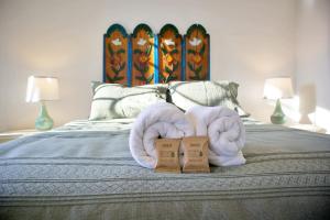 a bed with two towels on top of it at Stylish Art Déco Mexican House with rooftop in Guadalajara