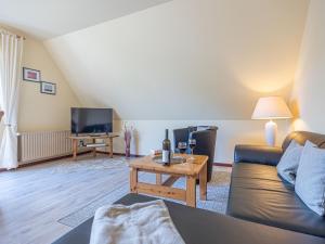 un soggiorno con un divano e un tavolo di La Casa Ferienwohnung Strandweg a Steinberg