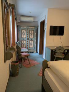 ein Hotelzimmer mit Bett und Fernseher in der Unterkunft Hotel Odenwaldblick in Rödermark