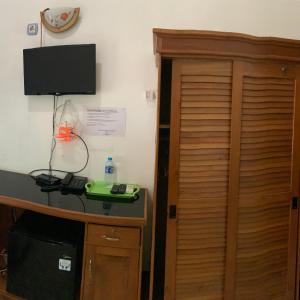a room with a desk with a phone and a television at Hotel Nascar Famili in Palangkaraya +7 photos