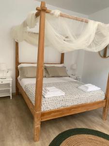 a bedroom with a wooden bed with a canopy at Il Belvedere di Babbo in Fasano
