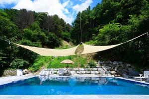 a hammock is hanging over a swimming pool at Haneulbit gwangang nongwon in Chuncheon