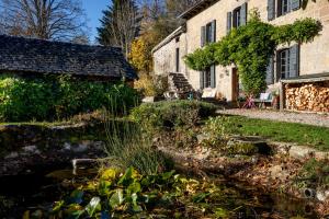an old house with a garden in front of it at Chambres d'hôtes le Clou in Thiézac
