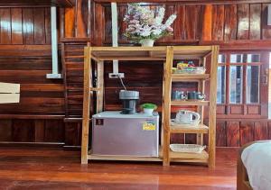 a kitchen with a shelf and a small refrigerator at I-Lay House Koh Kood in Ko Kood