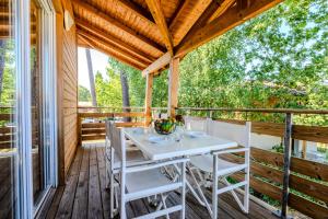un tavolo bianco e sedie su una terrazza in legno di Appartement de type 2 cabine pour 4 personnes a Parentis-en-Born