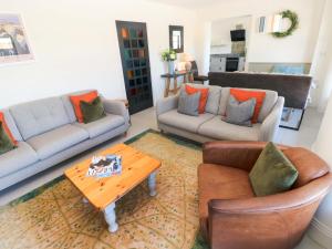 a living room with two couches and a coffee table at Just A Cottage in Tenby
