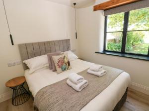 a bedroom with a bed with towels on it at Just A Cottage in Tenby