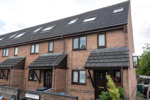 a brick house with solar panels on the roof at Courtsknap Contractors Sleeps 9 Free Parking WiFi in Swindon
