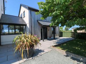 a house with a garden and a driveway at Just A Cottage in Tenby