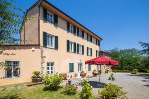 a building with a red umbrella in front of it at Villa al Falchetto by VacaVilla in Capannori +51 photos