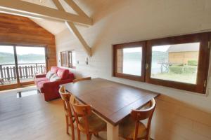 a living room with a wooden table and chairs at Rare petit chalet sur le lac barque à rames clim in Aiguebelette-le-Lac