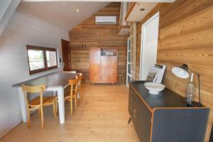 a kitchen with a table and chairs in a house at Rare petit chalet sur le lac barque à rames clim in Aiguebelette-le-Lac +10 photos