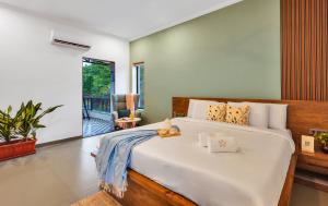 a bedroom with a large bed in a room at SaffronStays Fernshade - 3BR Khopoli retreat, patio, lawn picnics & riverside walks, quick Mumbai access via Atal Setu in Jambhulpāda