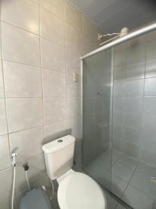 une salle de bain avec toilettes et douche en verre dans l'établissement Pousada Coco Verde Natal, à Natal