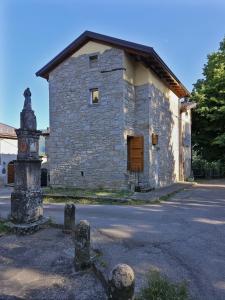un vieux bâtiment en pierre avec une horloge devant lui dans l'établissement La Coccola del Borgo, à Fanano