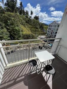 a white table and two stools on a balcony at Cameron 3room Golden Hills in Brinchang