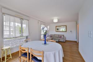 a living room with a table with a vase of flowers on it at Le Rev - à 900m de la plage in La Baule