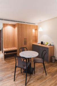 a kitchen with a table and chairs in a room at Milestone Suites by Robinson Properties in Trivandrum
